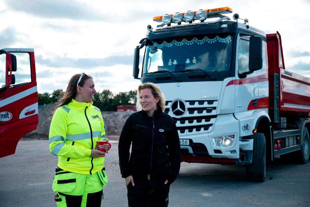 Två medarbetare framför lastbil